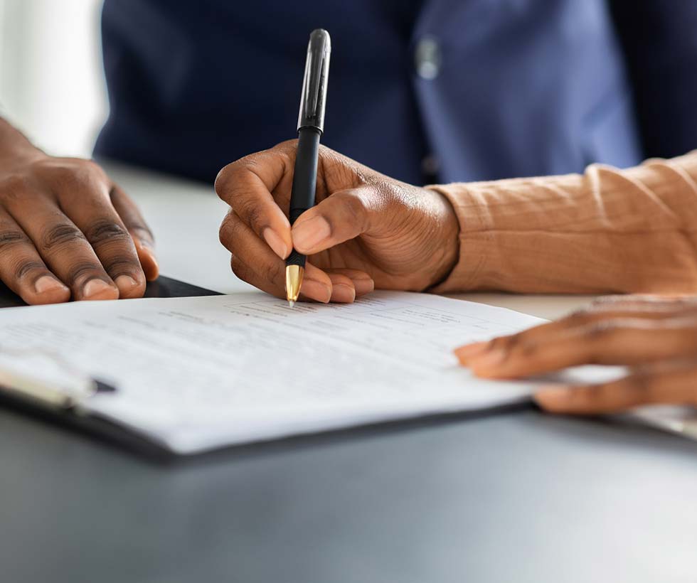 Close up of hands signing papers